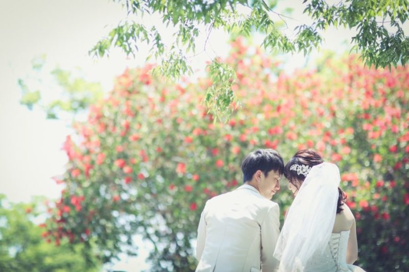 赤い木の前で撮影した大高緑地公園での結婚写真