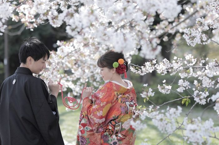 名古屋城の桜をバックに赤い糸で結ばれるふたり