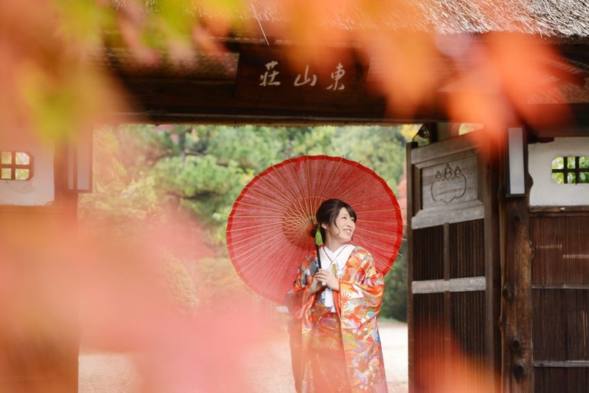 赤い和傘を持つ色打掛を着た新婦