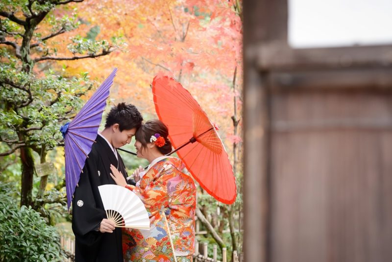 紫の和傘を持った新郎と赤い和傘を持った新婦